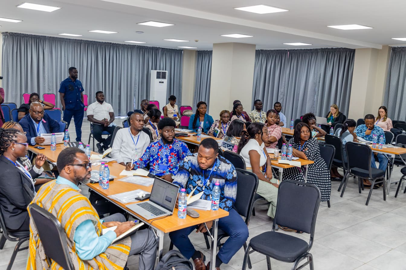 Participants working at tables with laptops and notes during a COTC Africa breakout session